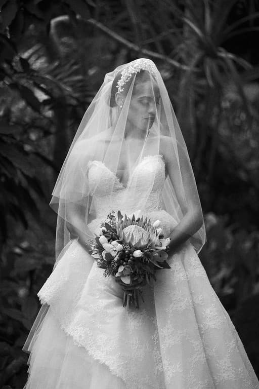 A bride in a full gown and veil holding a bouquet