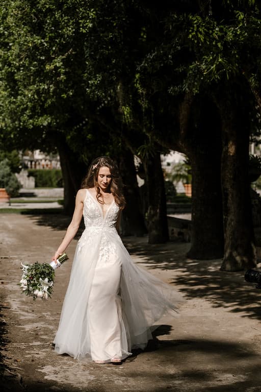A bride walking a garden path with a bouquet