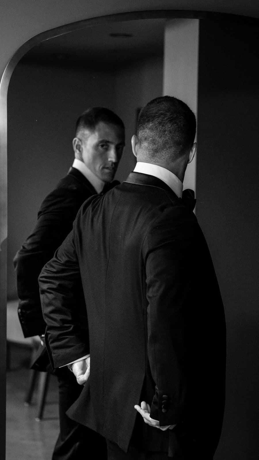 Black and white portrait of Chris smiling in a tuxedo