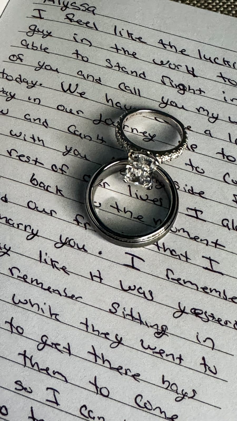 Wedding bands resting on a handwritten note
