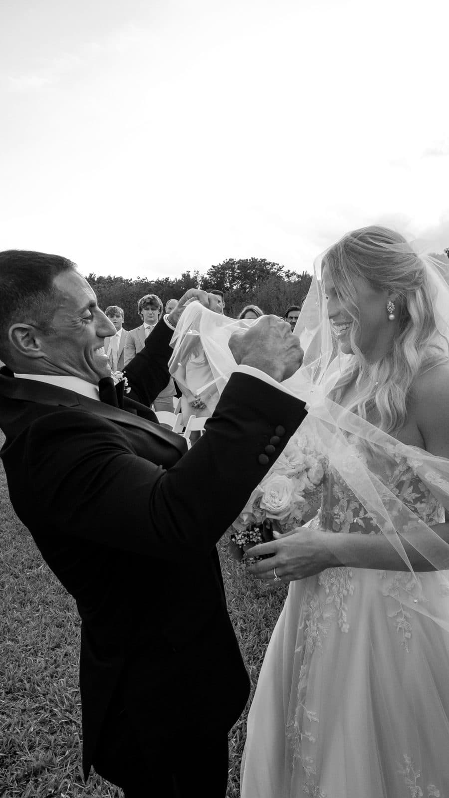 Alyssa and Chris kissing beneath a veil