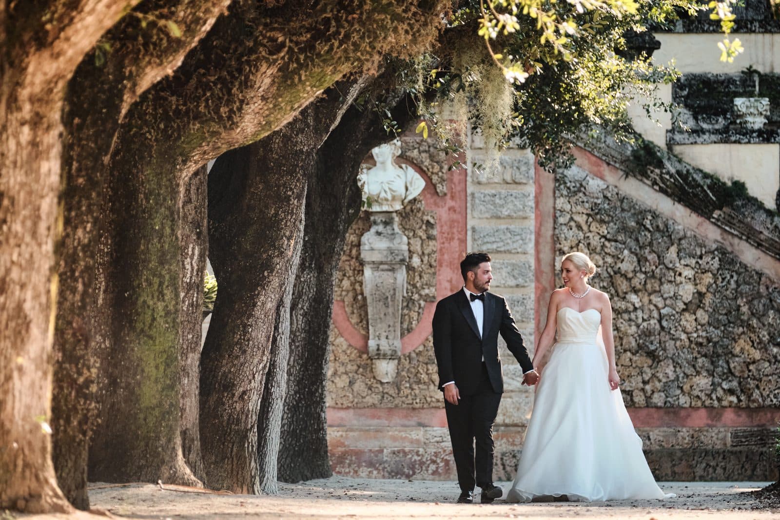 Amy and Chris walking a gravel path under string lights