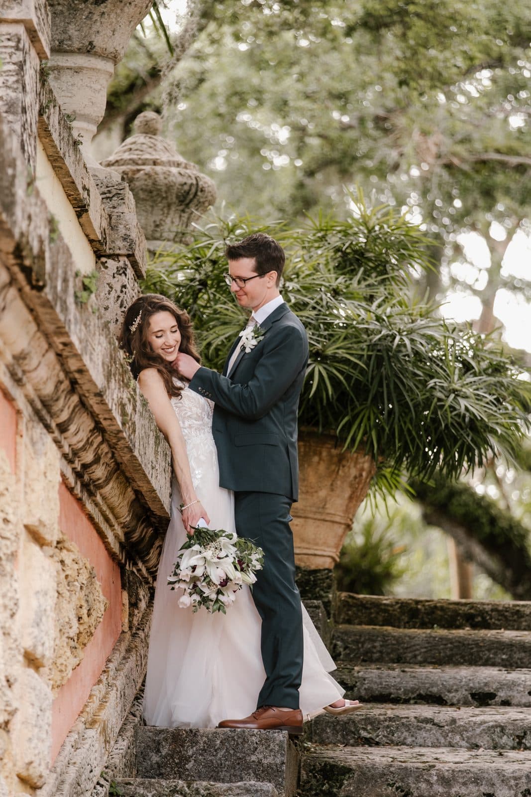 Chloe and Michael under an arch with the gardens behind them