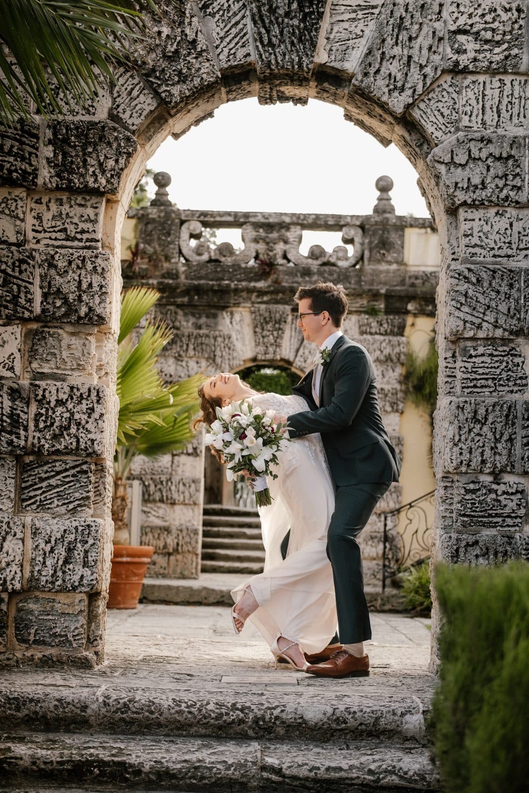 Chloe and Michael in the arches, her gown catching the light