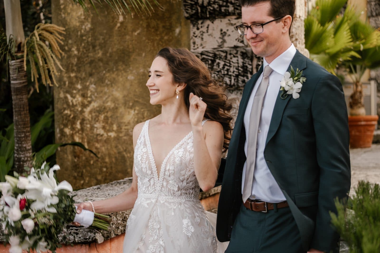 Chloe and Michael holding hands under an arch