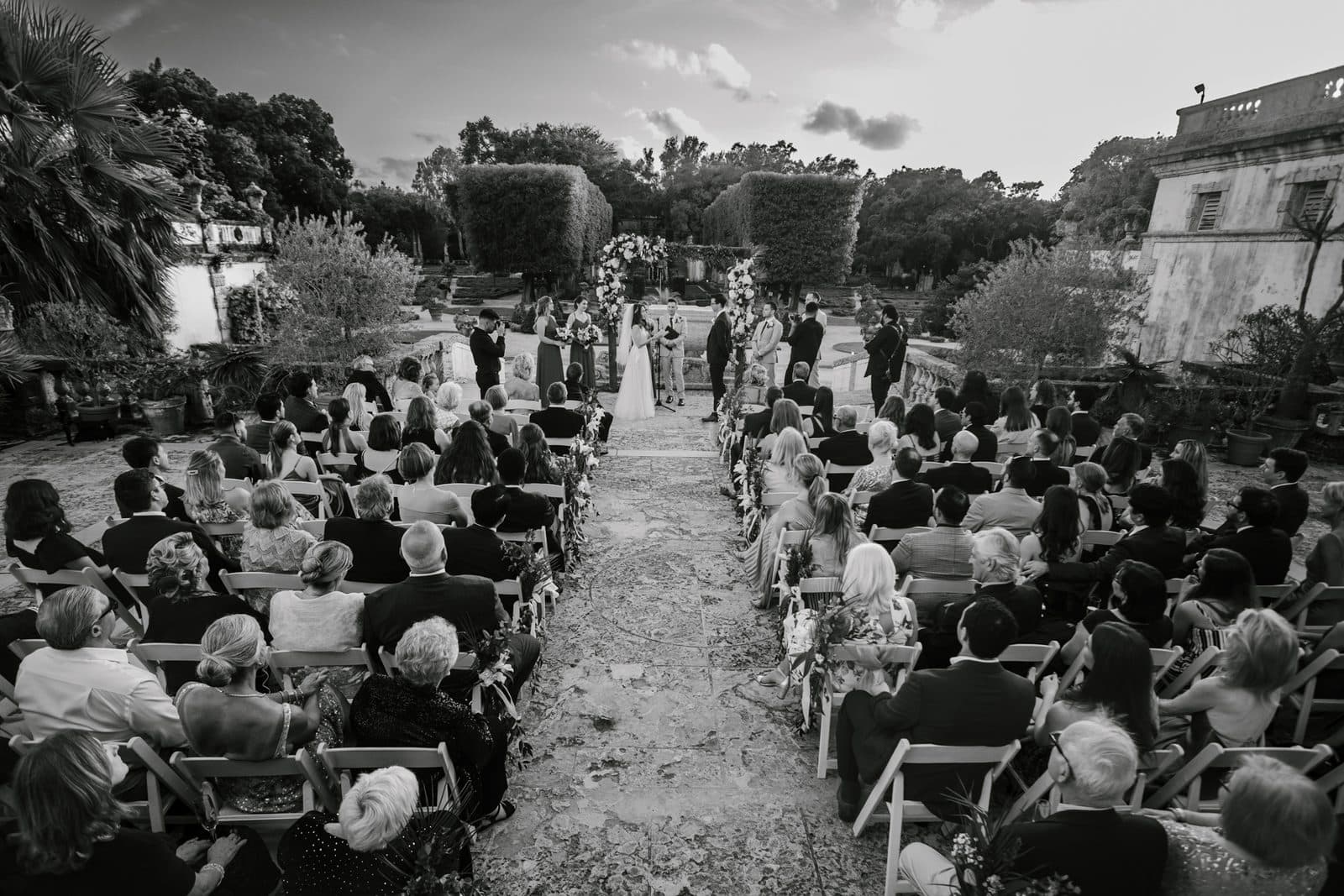 Chloe and Michael walking a garden path at Vizcaya
