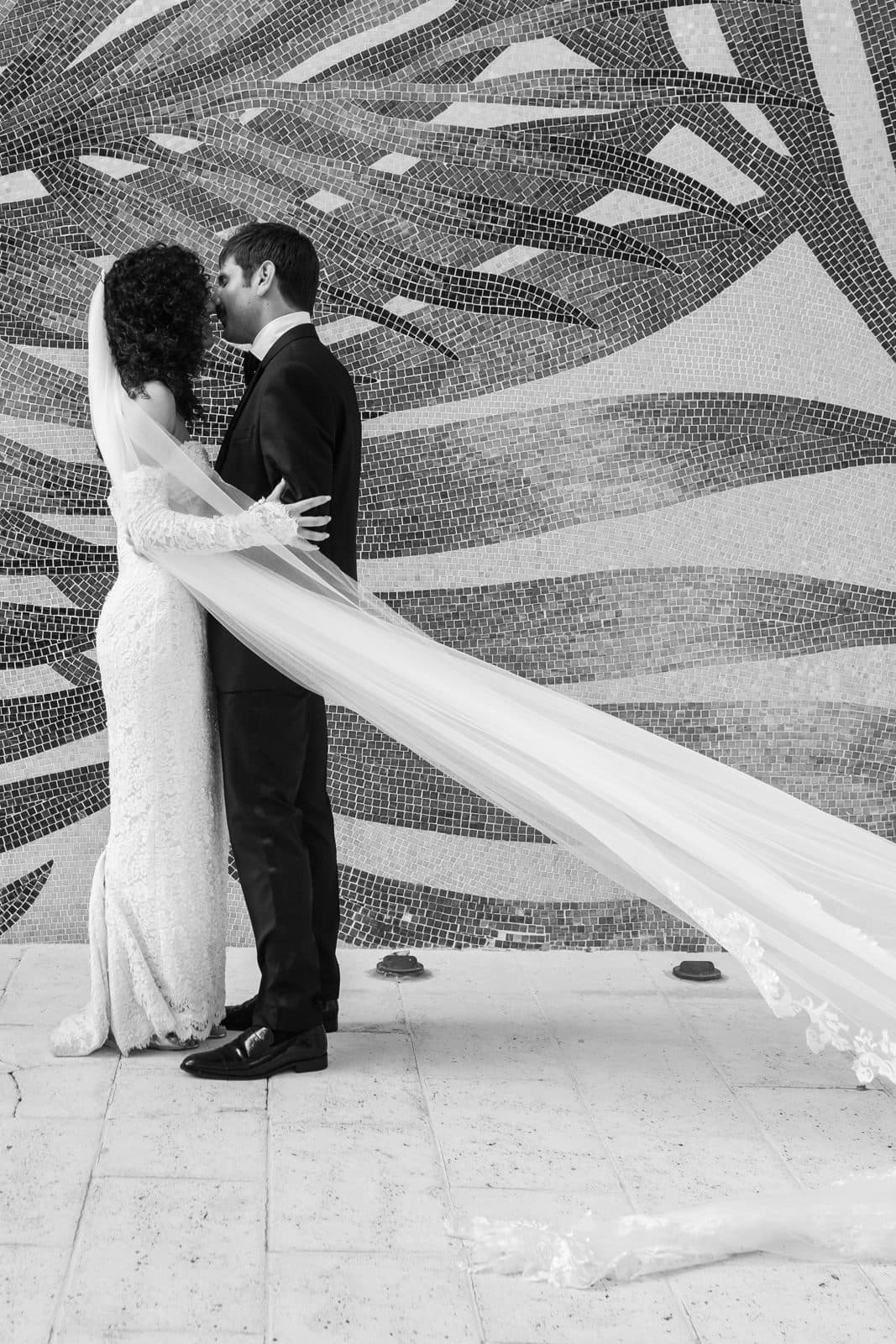 Sophia and Patrick kissing beside the vintage car